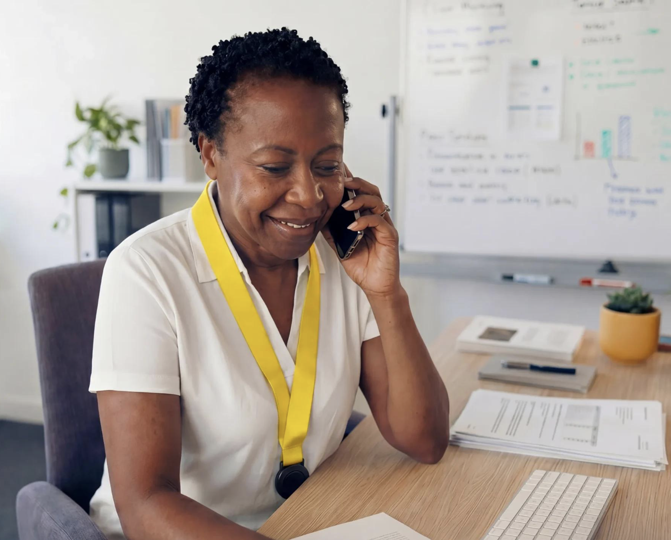 A bereavement coordinator on the phone, smiling while working at a desk