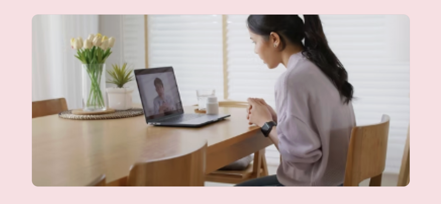 A woman using a laptop for a video call in a bright, calm home